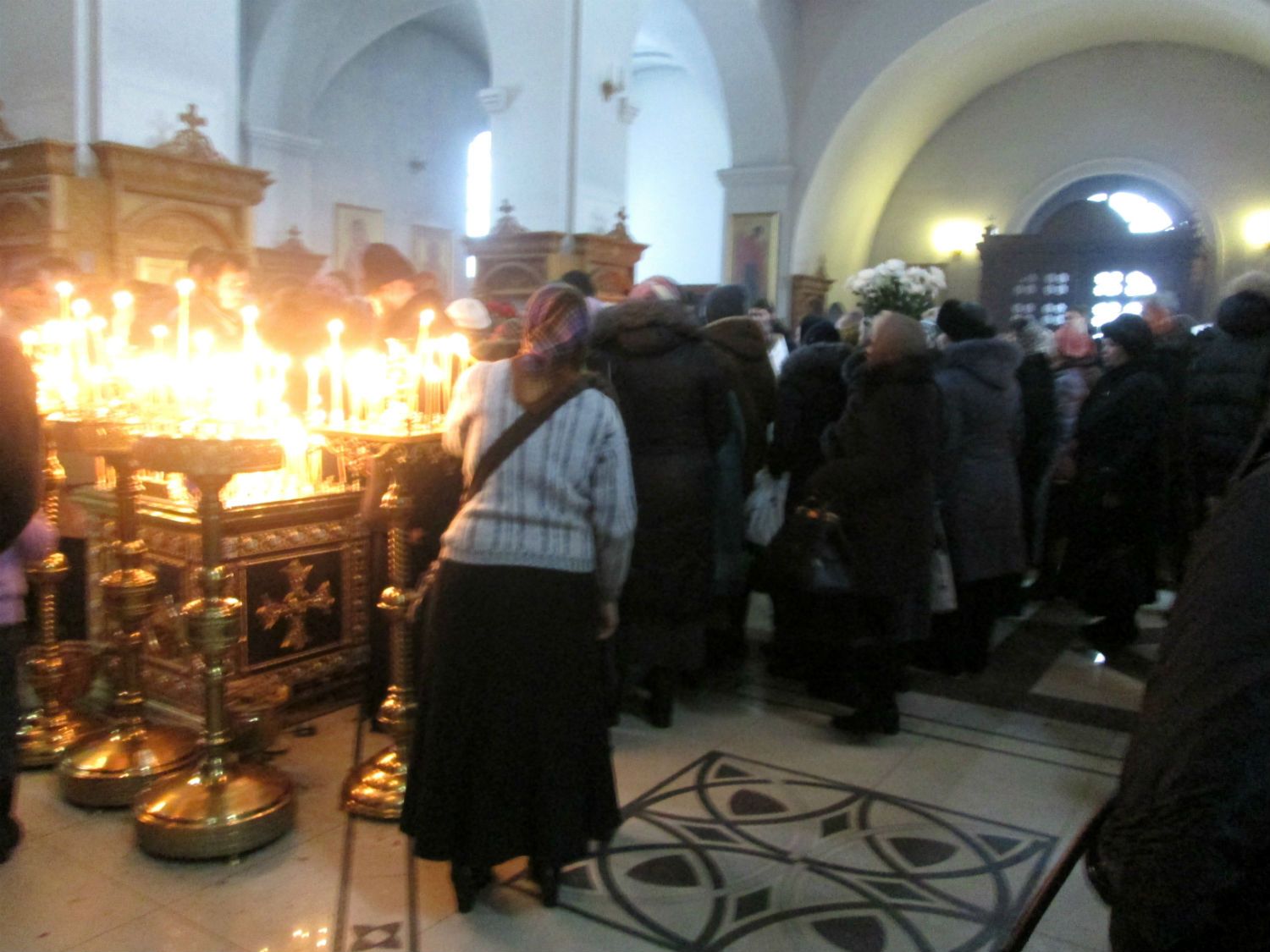 В храме верующие ставят свечки об упокоении души старца