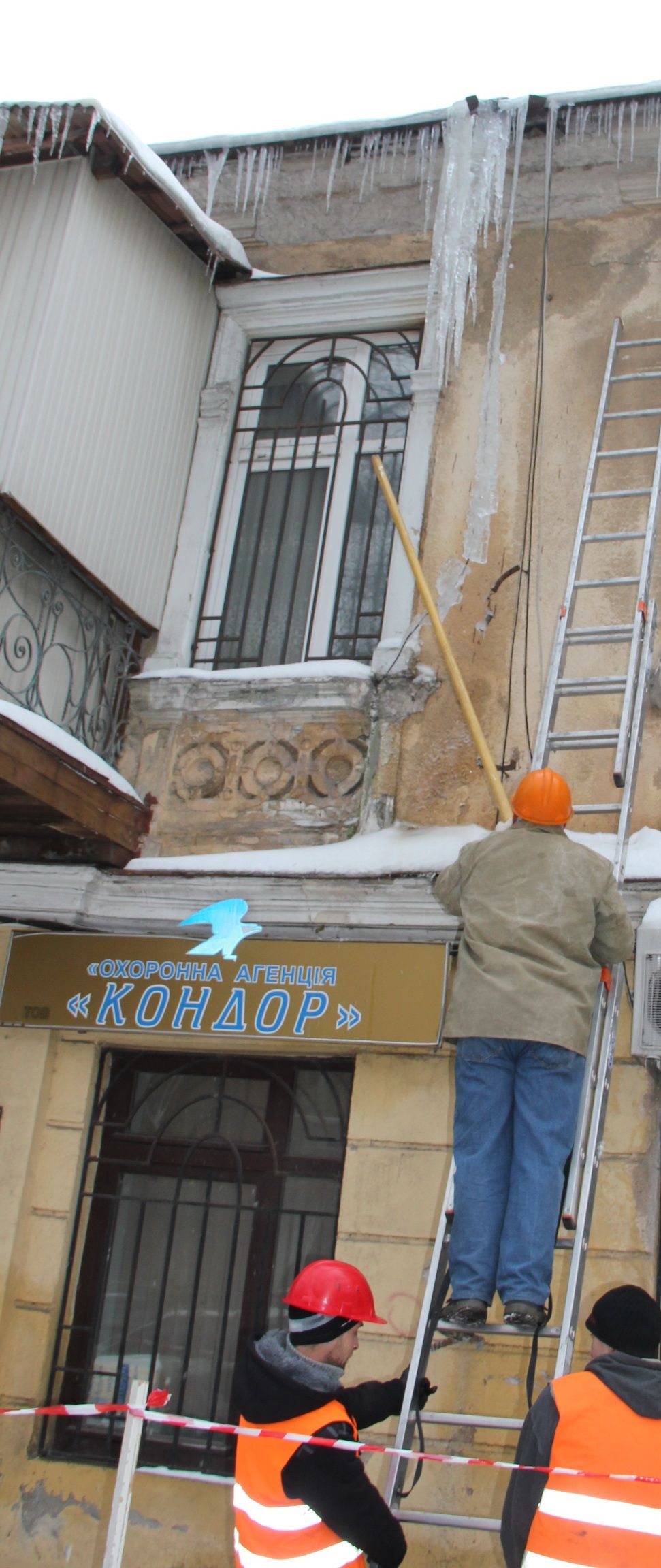 Коммунальщики сбивают сосульки на урышах домов