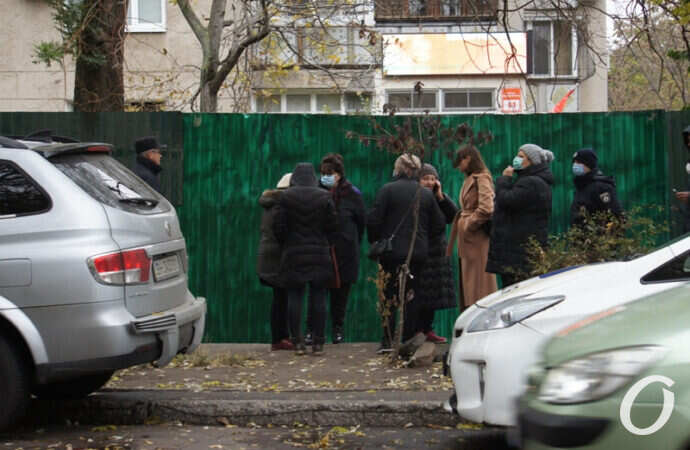 люди в черном у забора