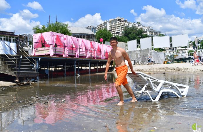 парень несет шезлонг, унесенный ливнем