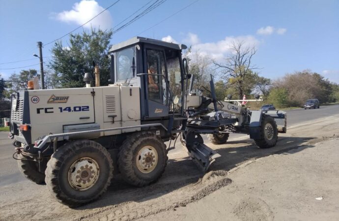 грейдер ровняет дорогу