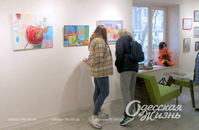 Женщины смотрит на картины на выставке