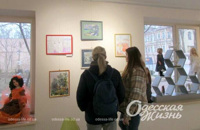 Женщины смотрит на картины на выставке