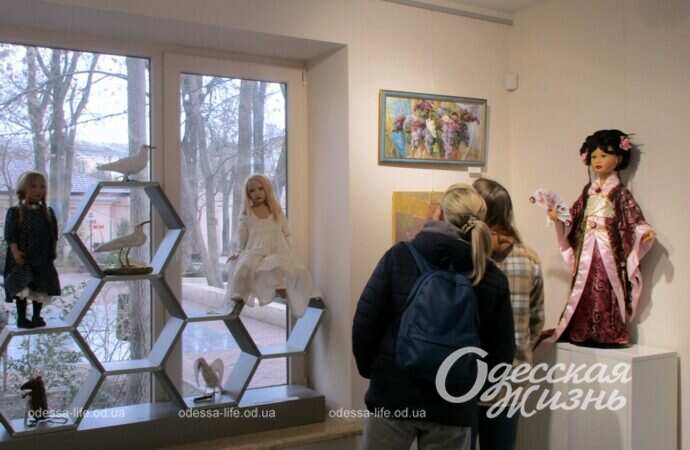 Женщины смотрит на картины на выставке