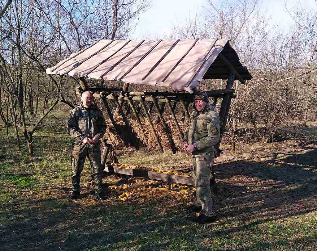 Лісничий Володимир Клочков (праворуч) біля годівниці для парнокопитних