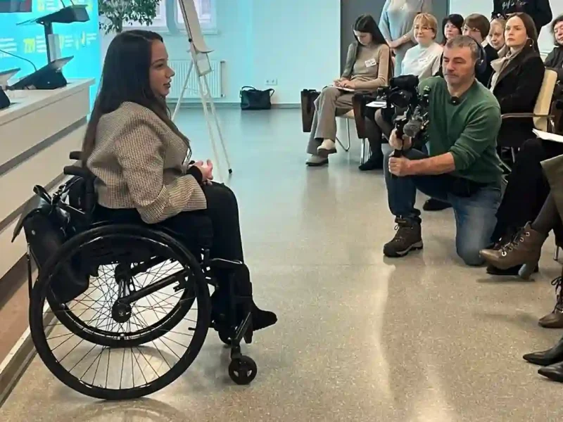 Тренінг з безбар’єрності для працівників банку: спікерка на кріслі колісному спілкується з учасниками під час навчальної сесії.