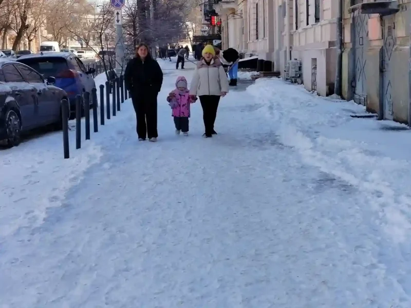 Люди йдуть по засніженому тротуару