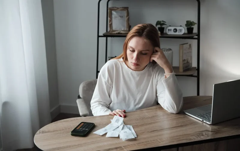 жінка з чеками за столом, фінансовий контроль у родині