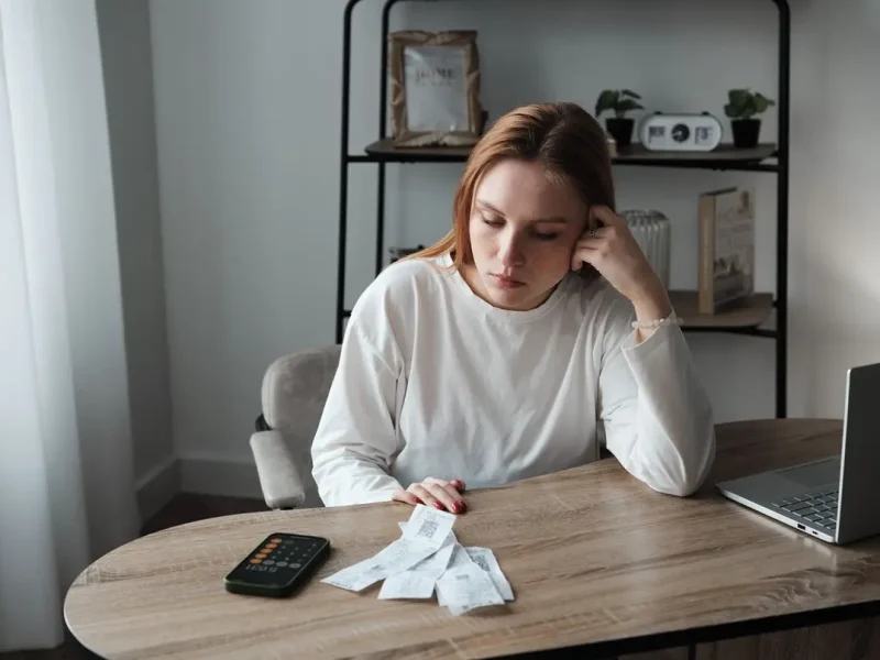 жінка з чеками за столом, фінансовий контроль у родині