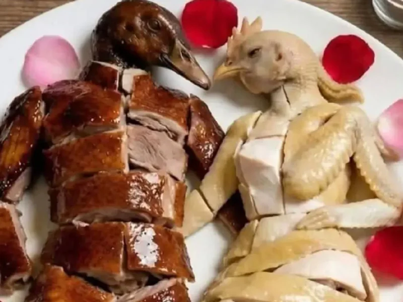 Смешное блюдо из курицы и утки в виде человеческих фигур на тарелке с лепестками роз