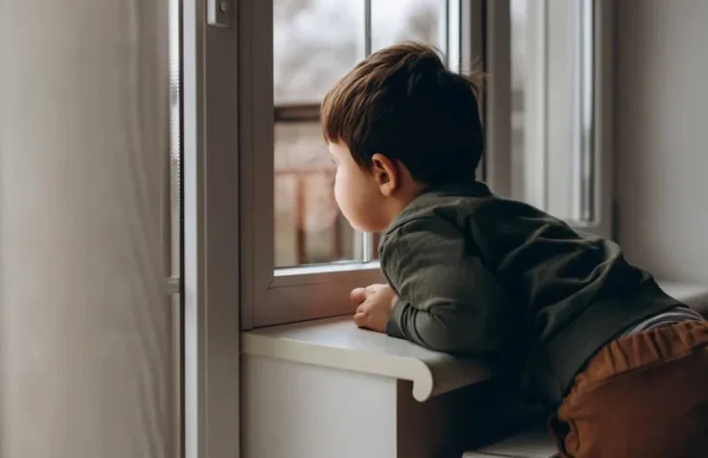 Дитина дивіться у вікно - чекая батька