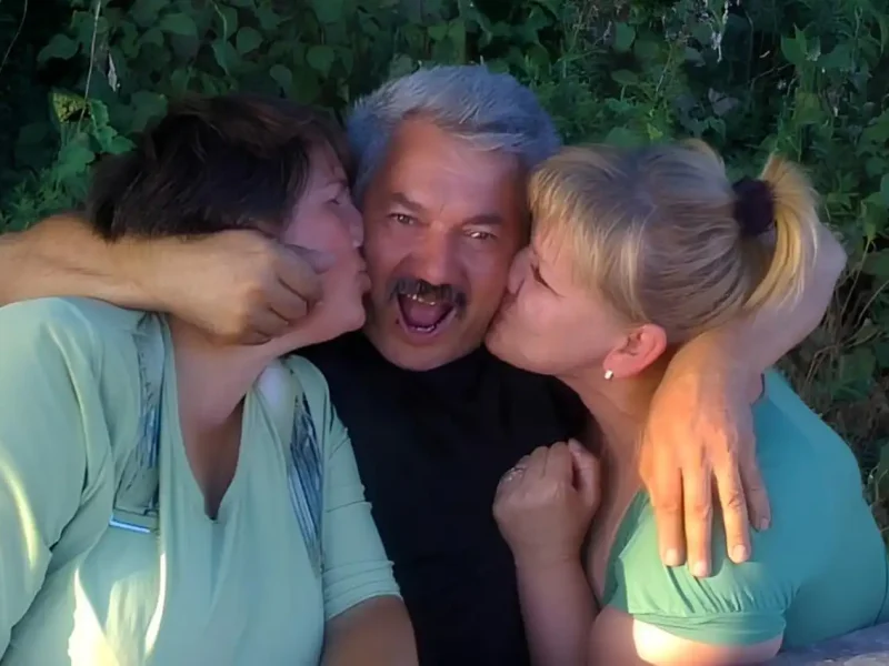 Дружина й донька цілують чоловіка