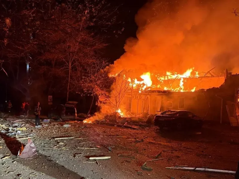 Вид на разрушенный и горящий двухэтажный жилой дом в Одессе. Сильные повреждения крыши и балконов, открытый огонь, ночь