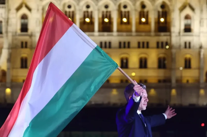 Петер Мадьяр держит в руках флаг Венгрии