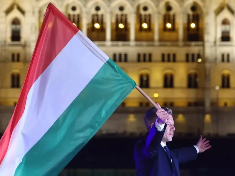 Петер Мадьяр держит в руках флаг Венгрии