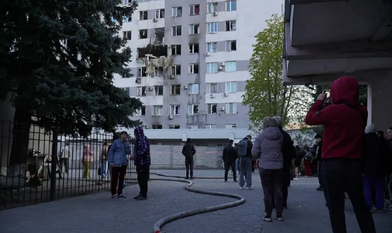 Разрушенный фасад девятиэтажки в Одессе после атаки дрона, пожарные рукава на асфальте