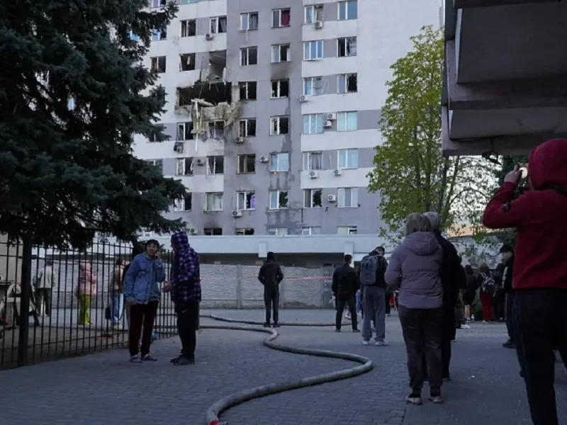 Разрушенный фасад девятиэтажки в Одессе после атаки дрона, пожарные рукава на асфальте