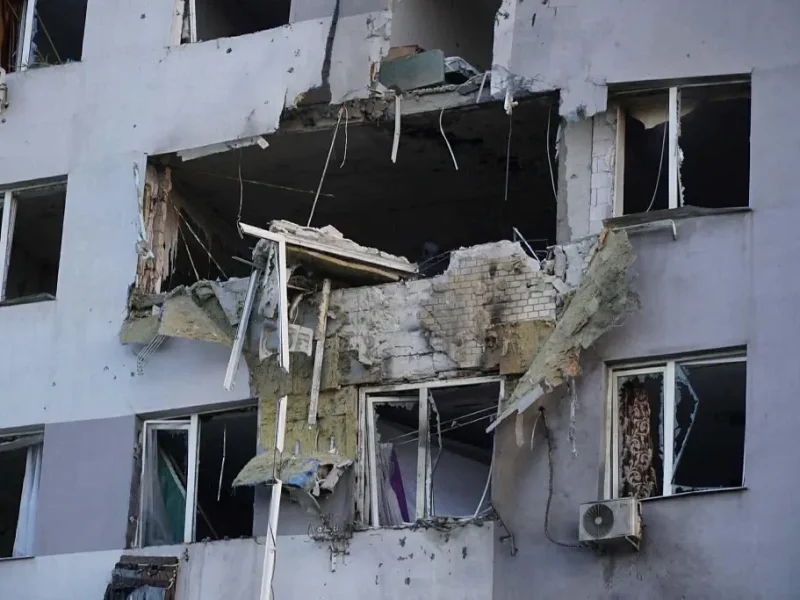 Крупный план дыры в бетонной стене многоэтажного дома после попадания шахеда.