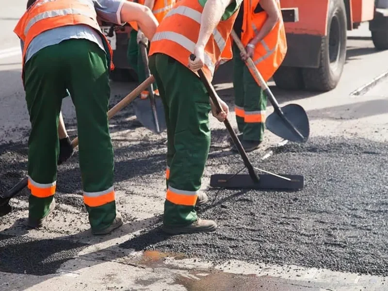 Дорожные работники ремонтируют тротуар