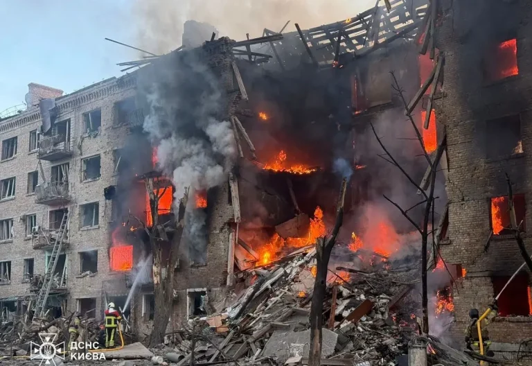Пожарные ГСЧС тушат огонь в разрушенном многоквартирном доме в Киеве, видны открытое пламя и обрушившиеся перекрытия