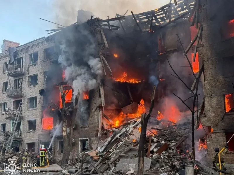 Пожарные ГСЧС тушат огонь в разрушенном многоквартирном доме в Киеве, видны открытое пламя и обрушившиеся перекрытия