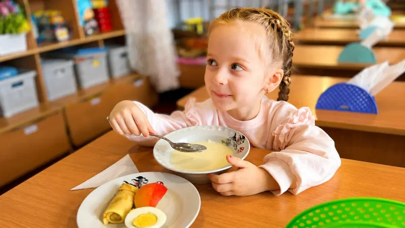 Дівчинка снідає у дитячому садочку