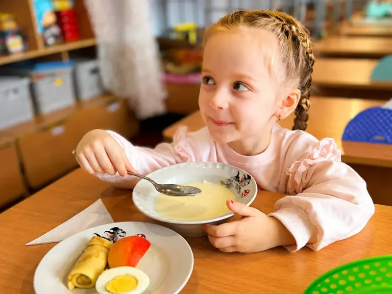 Дівчинка снідає у дитячому садочку