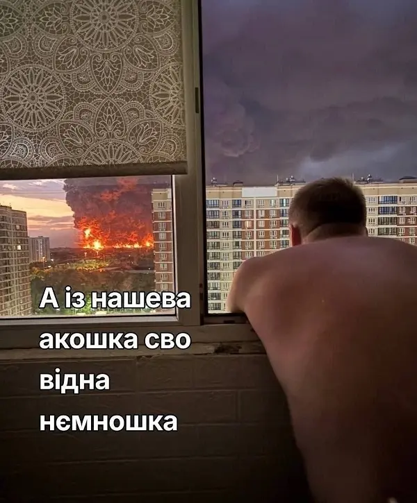Мужчина без рубашки смотрит из окна многоэтажки на сильный пожар в Подмосковье, мем с текстом на украинском