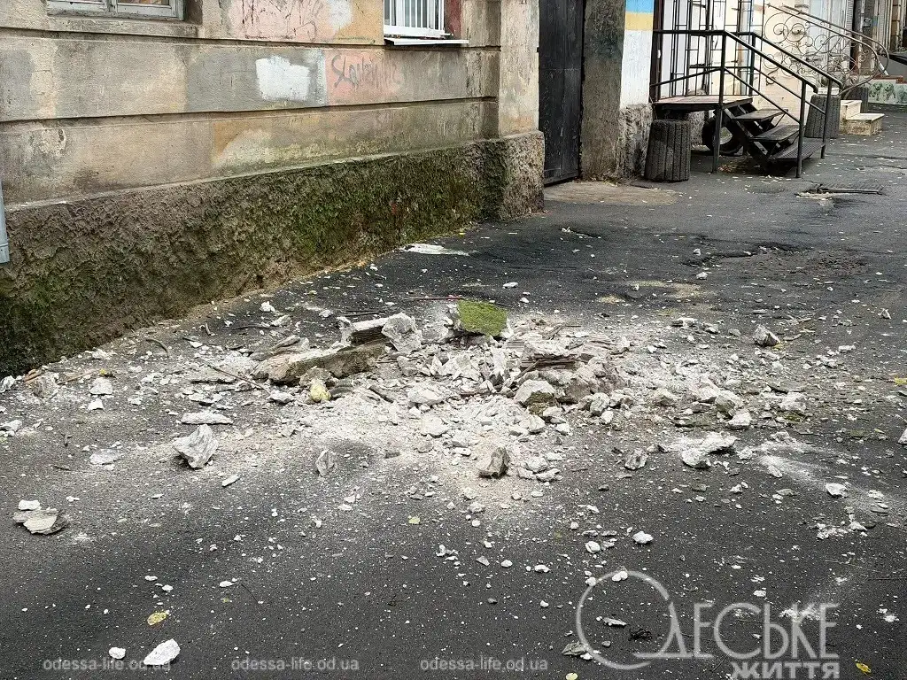 Одесса после ливня: Разбитые камни и строительный мусор, упавшие с крыши дома на пешеходную дорожку