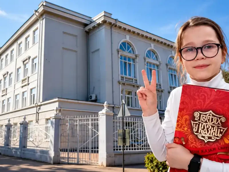 Школярка з книжкою біля школи